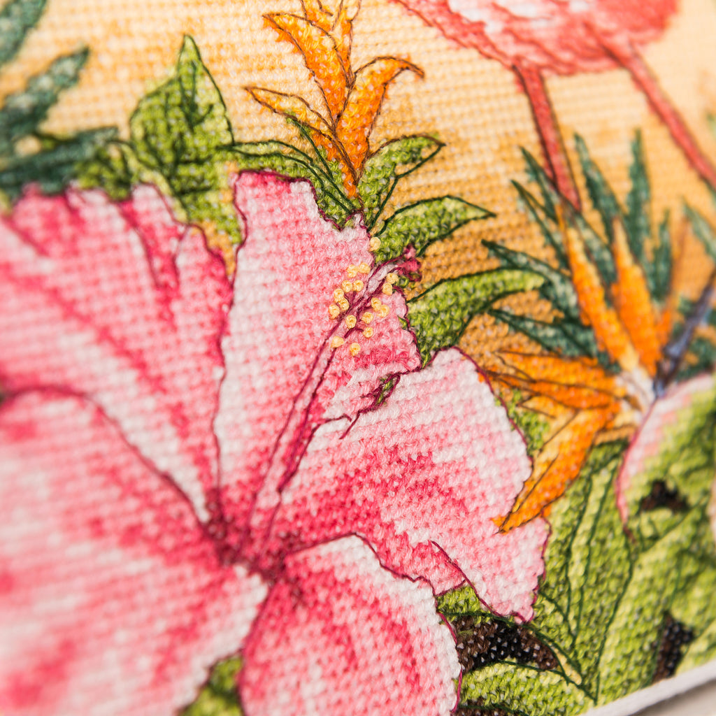 Close-up of a floral pattern with pink flowers and green leaves on a yellow background.