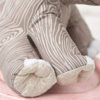 Close-up of a plush toy elephant with striped pattern on a pink surface