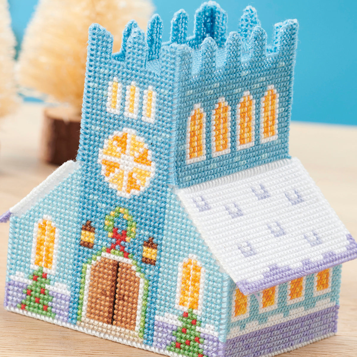 Decorative bead castle on a wooden surface with a blue background