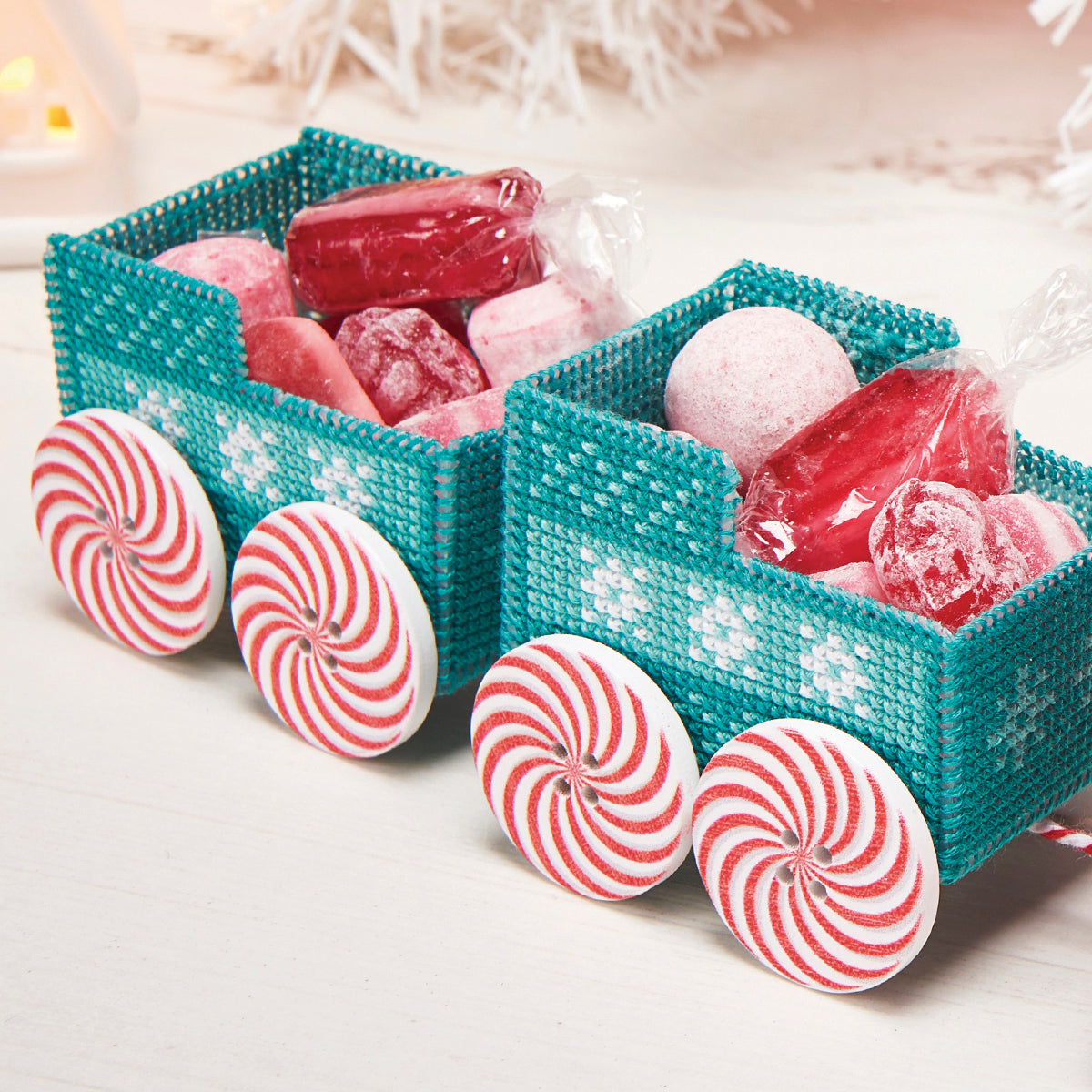 Teal woven candy train with red and white peppermint candies on a light background