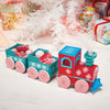Decorative train made of candy with a Christmas tree and presents in the background