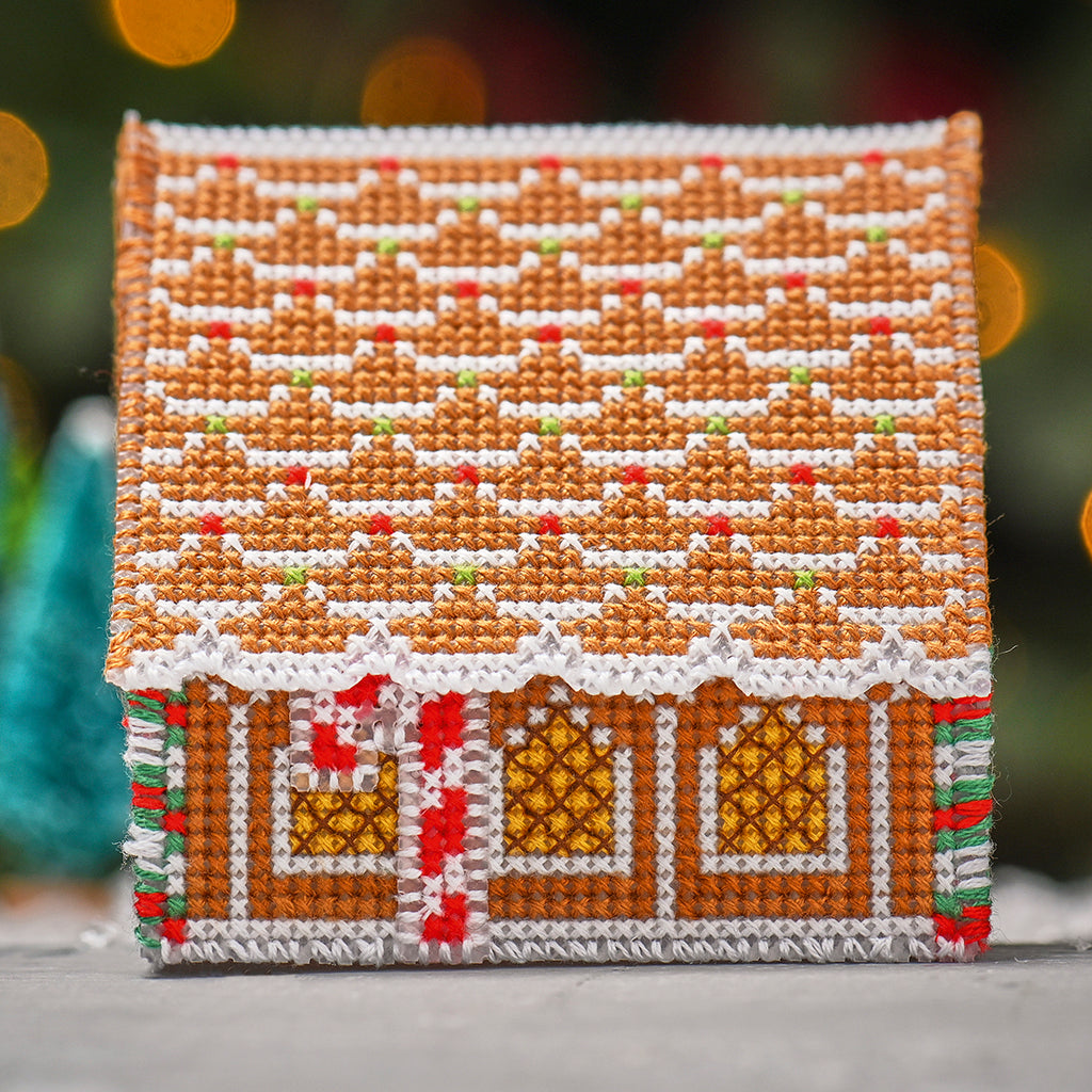 Cross-stitched gingerbread house on a blurred background