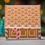 Cross-stitched gingerbread house on a blurred background