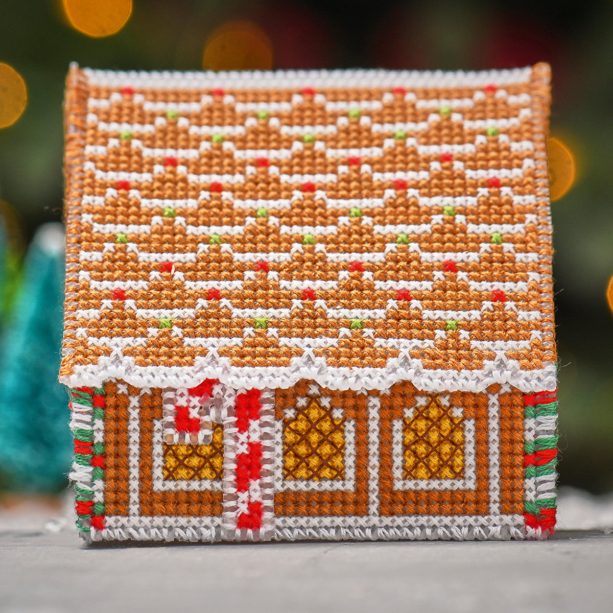 Cross-stitched gingerbread house on a blurred background
