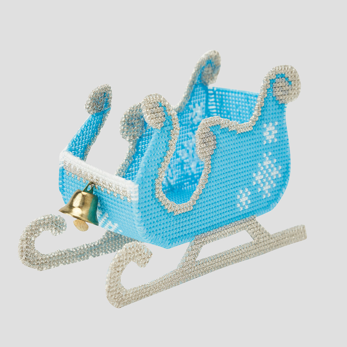 Decorative blue sleigh with silver trim and a gold bell on a light gray background