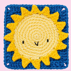 Crocheted square with a cheerful sun motif. Yellow sun with a smiling face is set against a bright blue background. Playful and whimsical design.