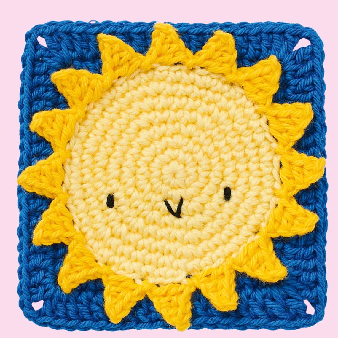 Crocheted square with a cheerful sun motif. Yellow sun with a smiling face is set against a bright blue background. Playful and whimsical design.