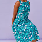 Green floral patterned dress on a person against a purple background