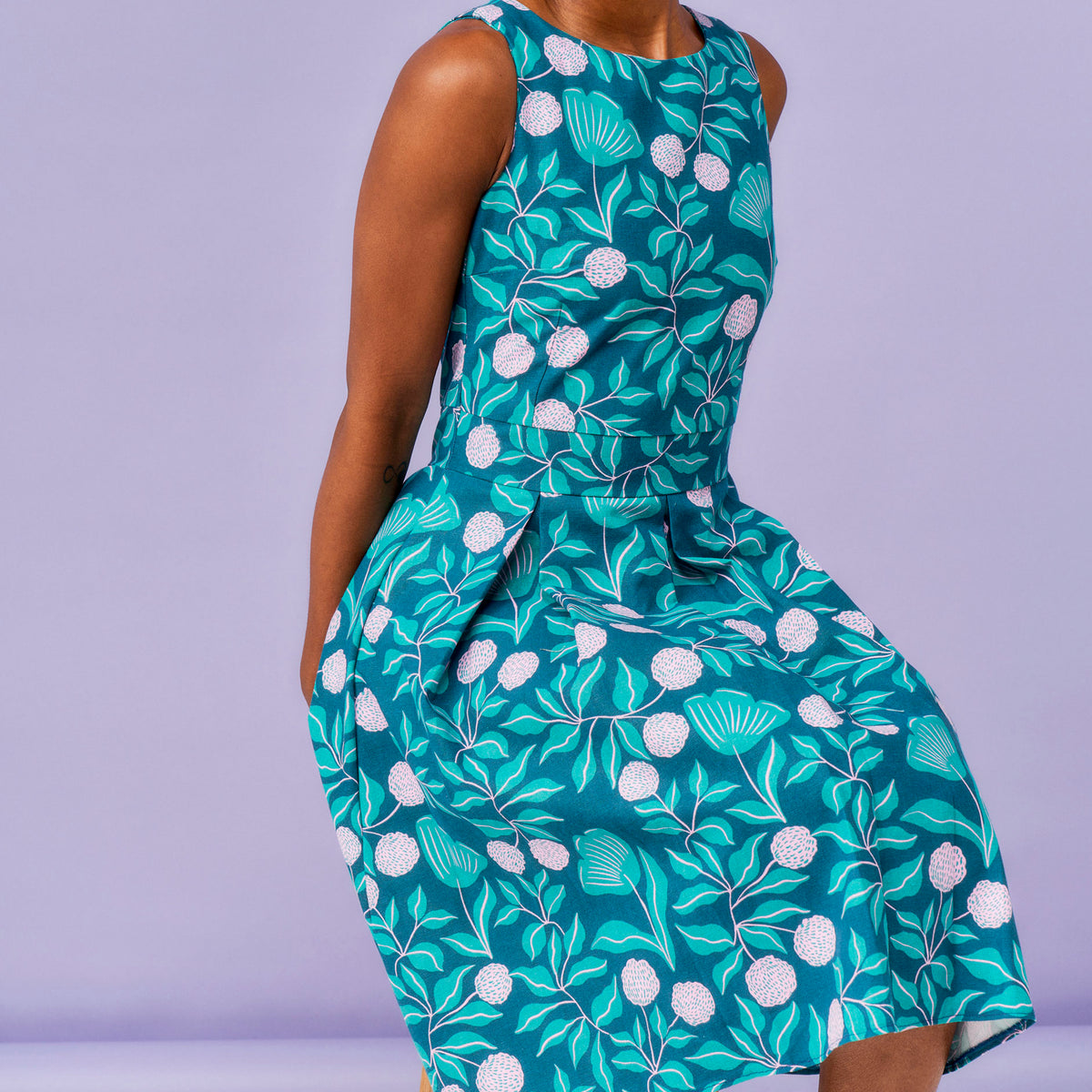 Green floral patterned dress on a person against a purple background