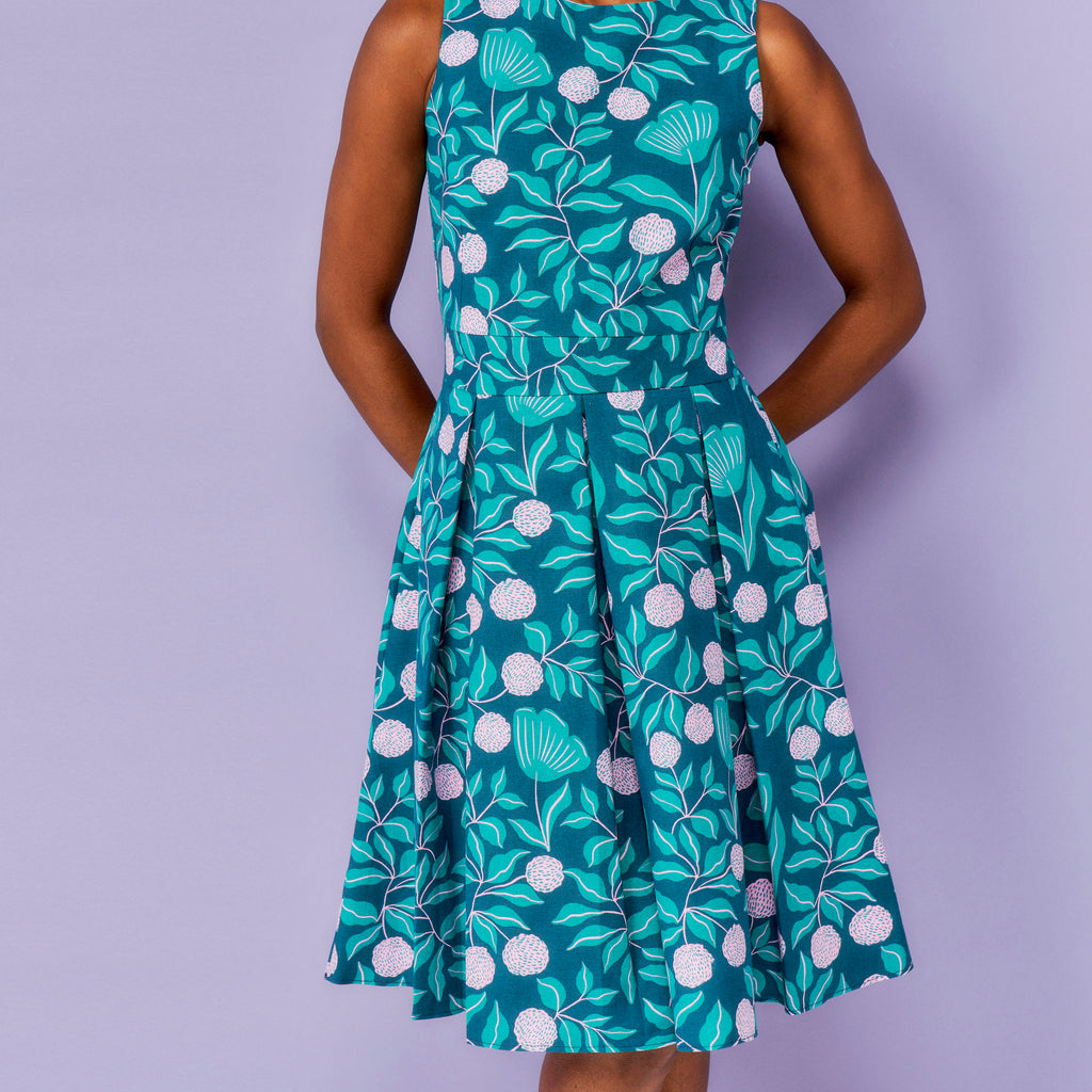 Green floral dress worn by a person on a purple background