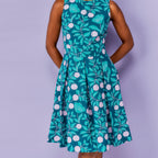 Green floral dress worn by a person on a purple background
