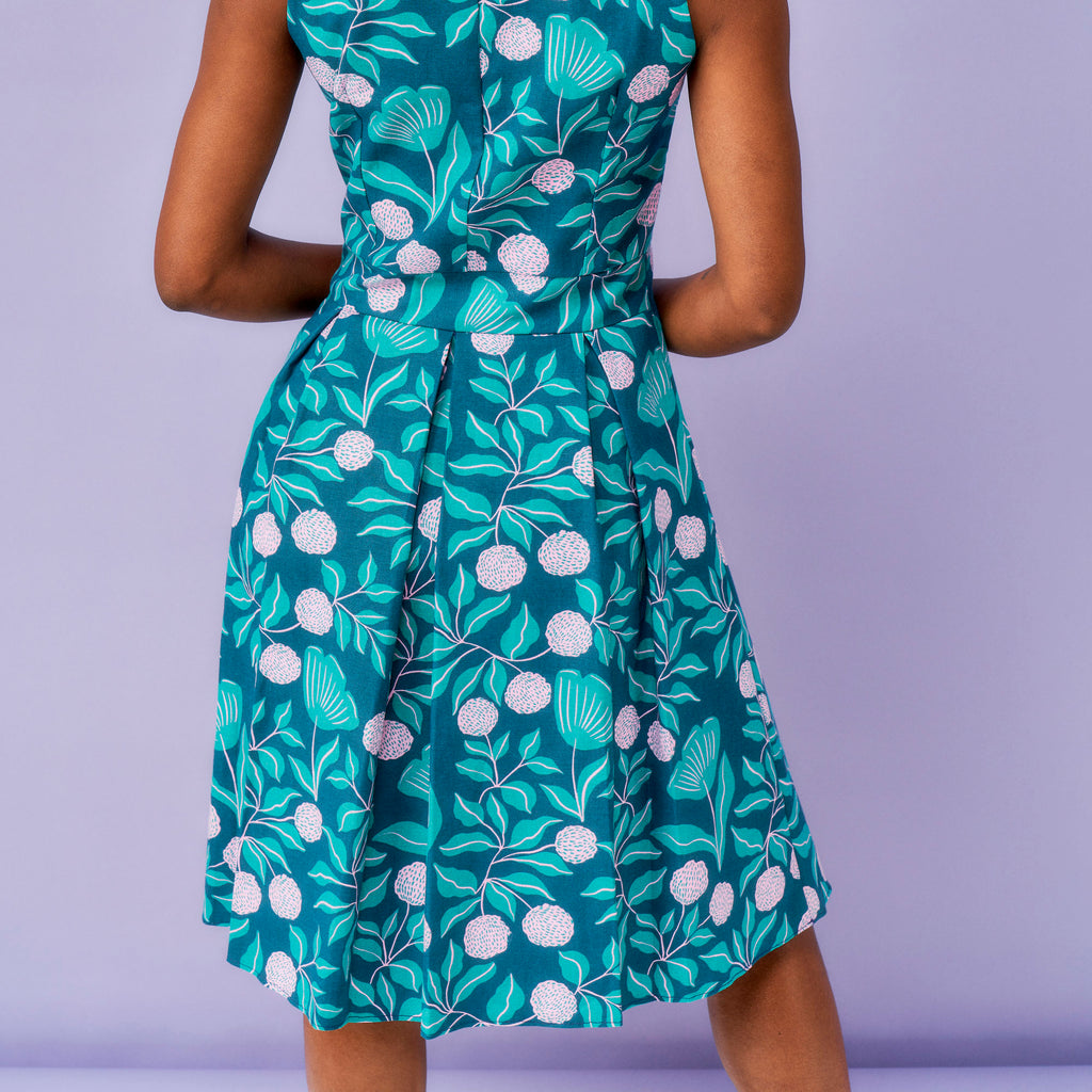 Green floral dress on a person against a purple background