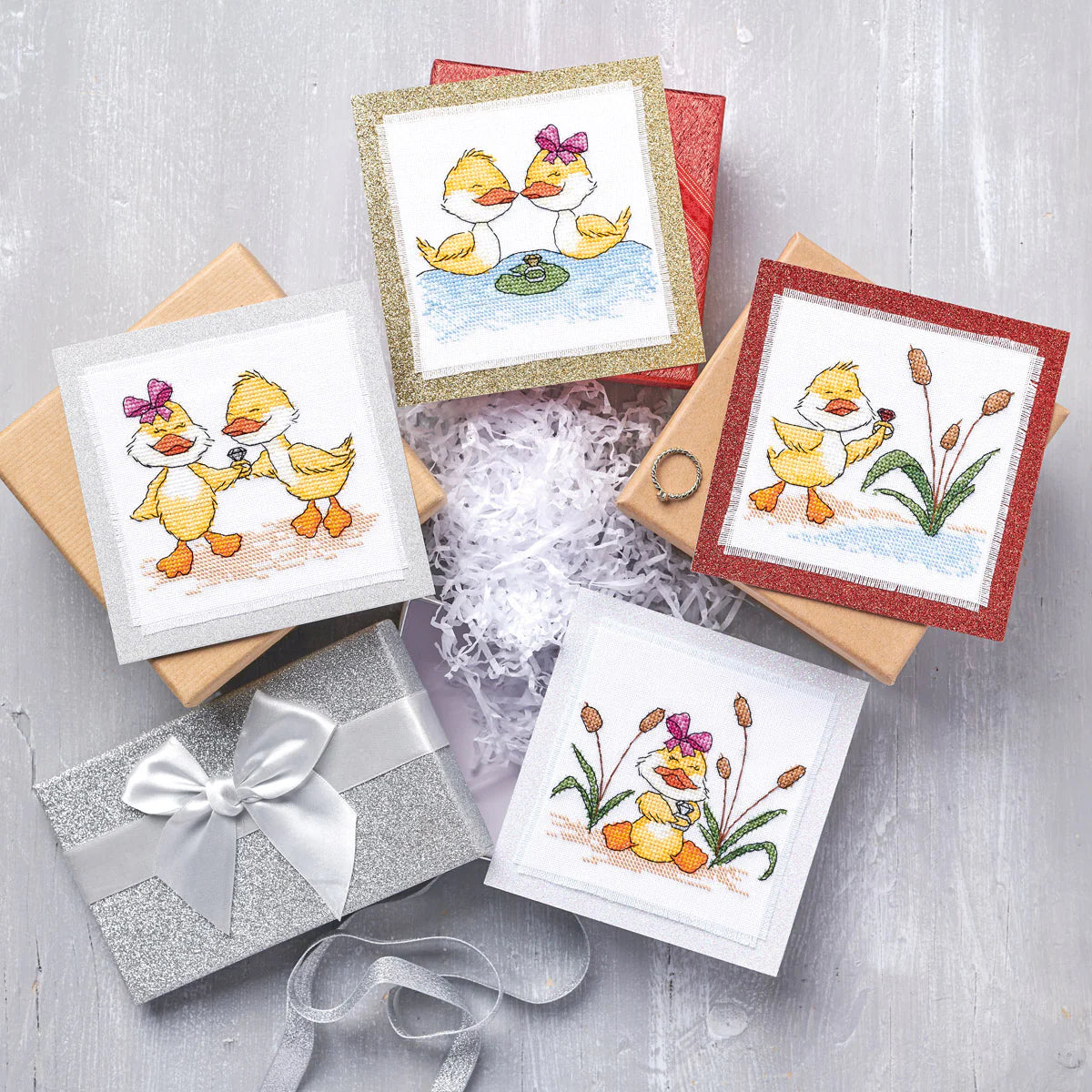 Set of greeting cards with duck illustrations on a gray surface
