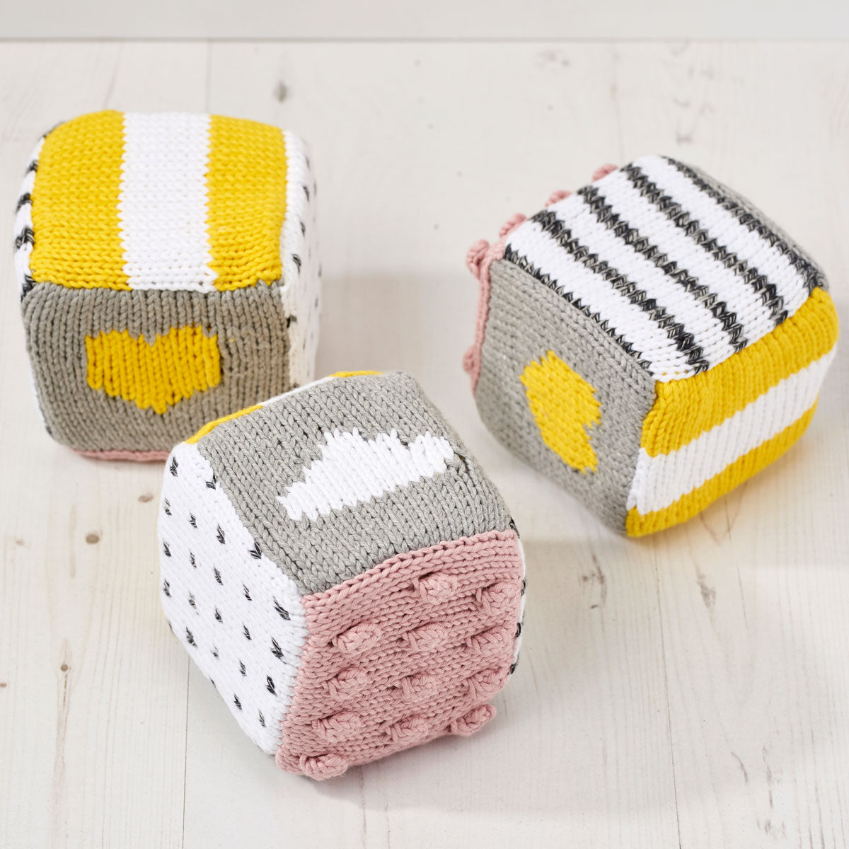 a set of colourful knitted baby blocks