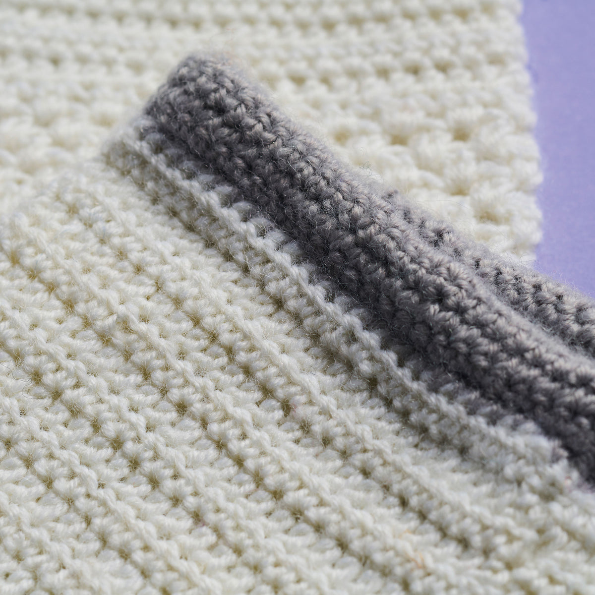 Close-up of a textured fabric with a stripe of gray fabric on top