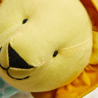 Close-up of a yellow plush toy with black details on a blurred background