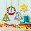 Colorful geometric decorations hanging on a light blue wall with stationery items on a wooden surface.