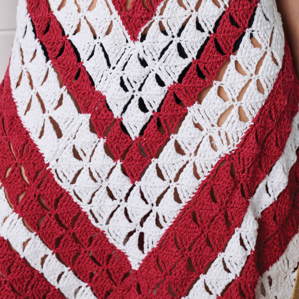 Red and white crocheted garment with a V-neck design.