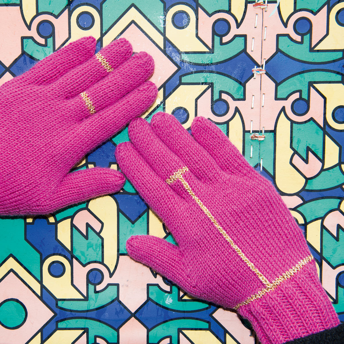 pink knitted gloves with gold details