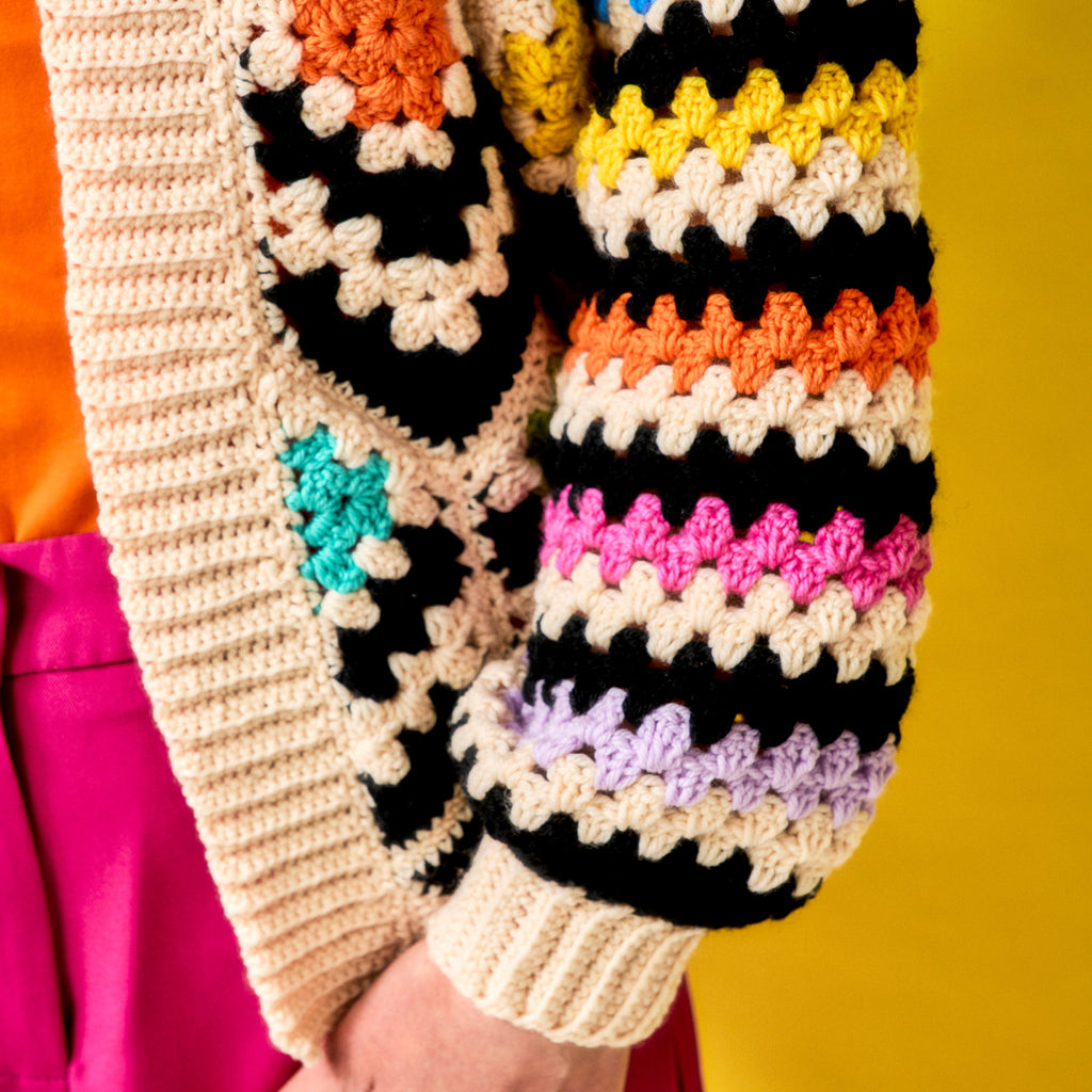 Colorful crocheted gloves with a pattern on a yellow background