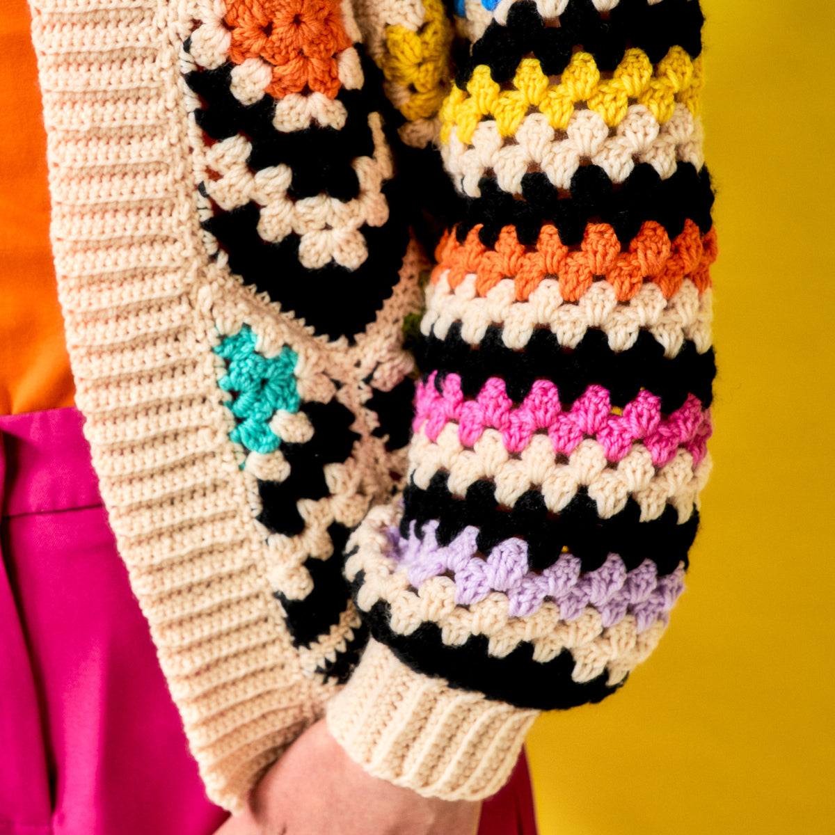 Colorful crocheted gloves with a pattern on a yellow background