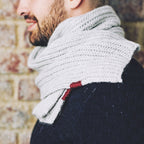 A man wearing a grey brioche stitch knitted scarf