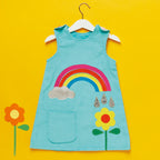 Children's dress with rainbow and flower design on a yellow background