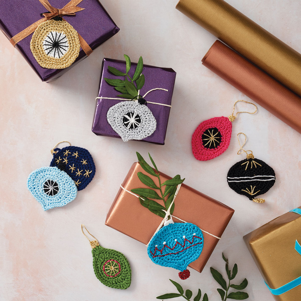 A collection of handcrafted Christmas gift tags in various colors, displayed on a table alongside gift boxes and decorative elements.