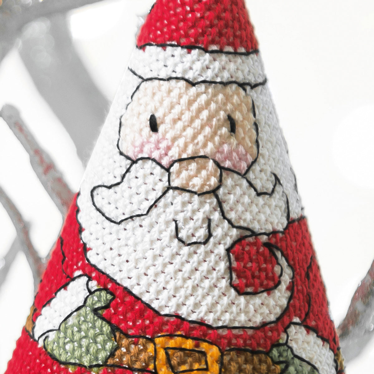 Decorative Christmas ornament with a cross stitch of Santa Claus on a white background.