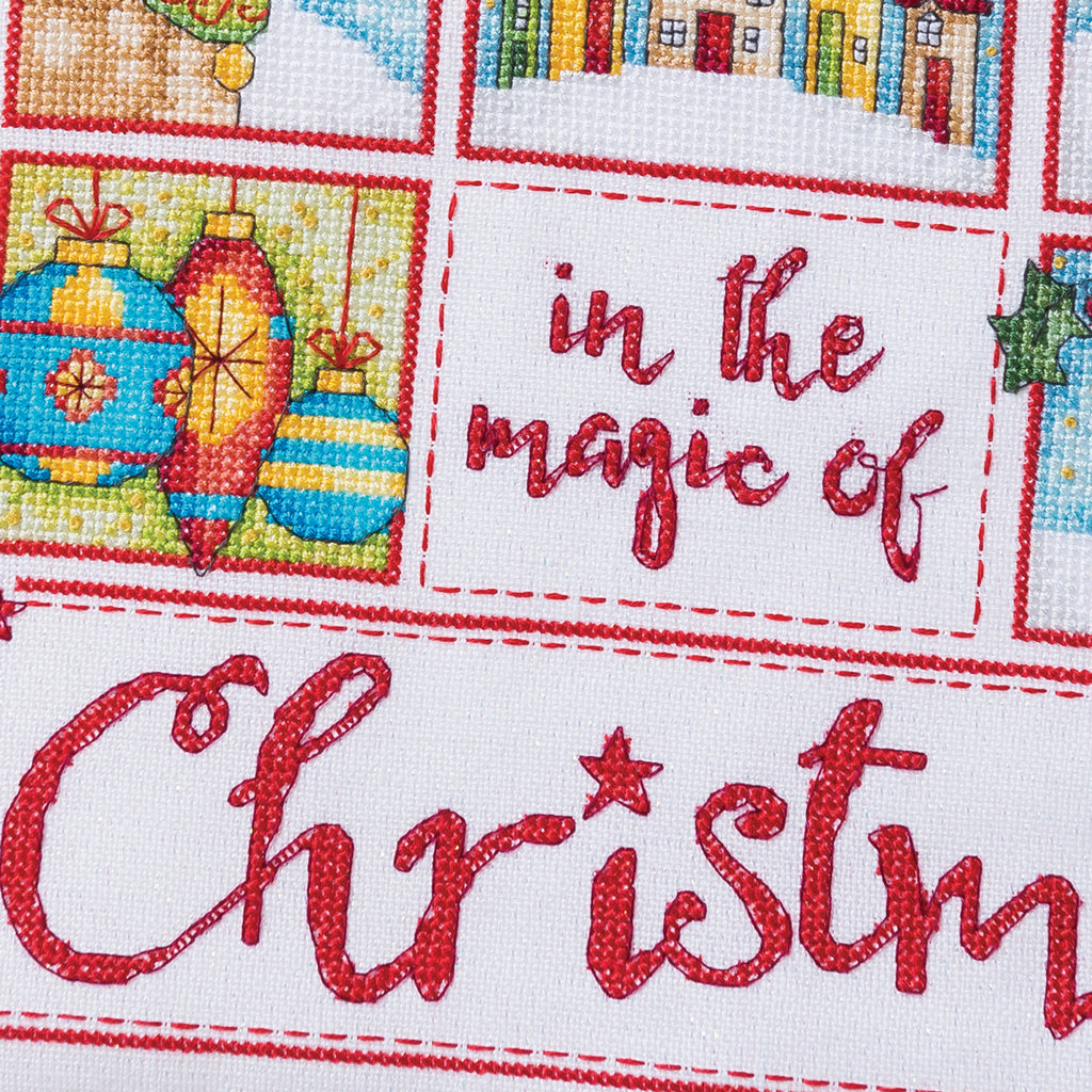 Cross-stitched text 'in the magic of Christmas' with festive designs in the corners.