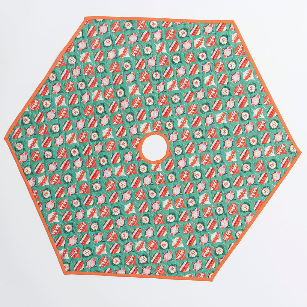 Hexagonal tree skirt with red and white pattern on a green background