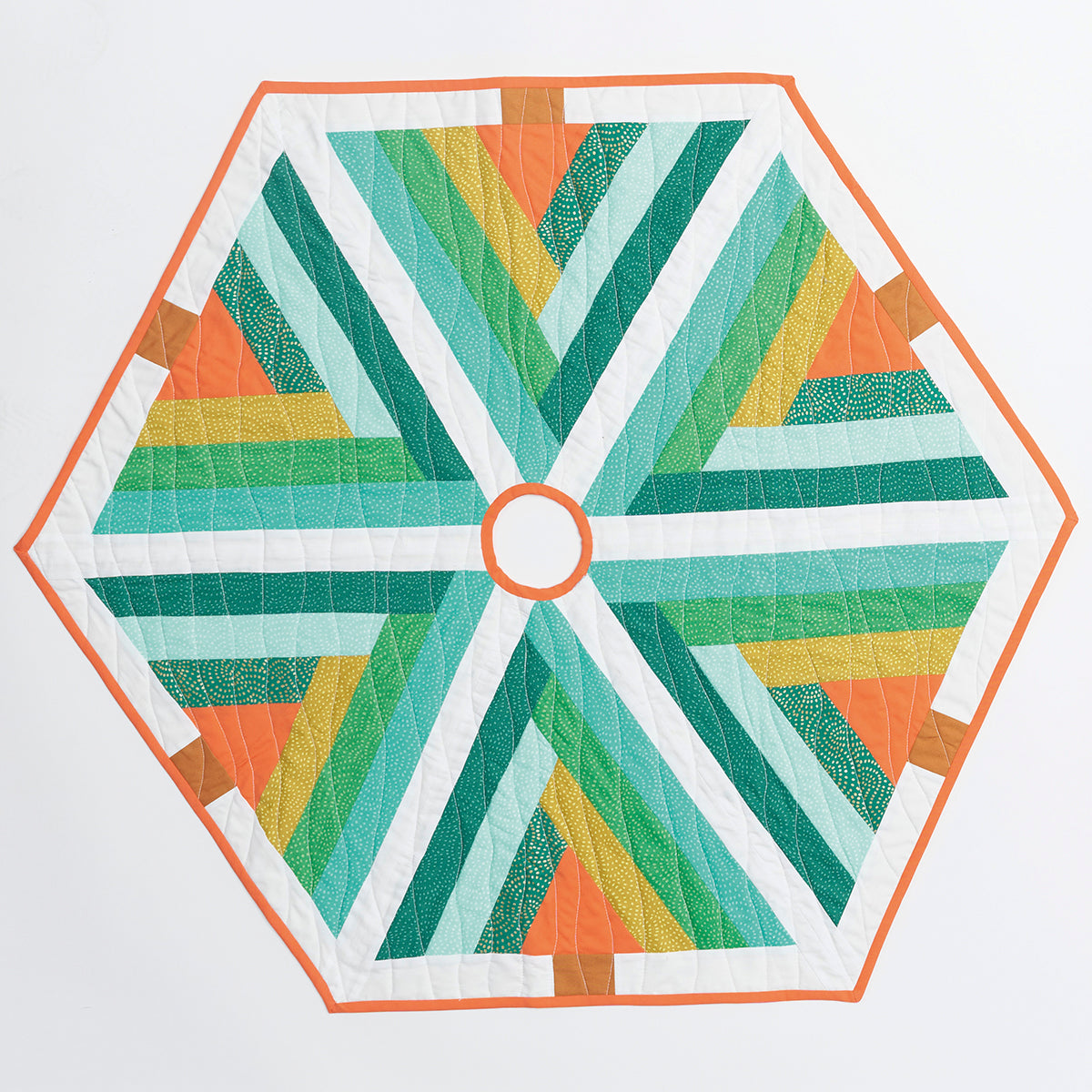 Hexagonal quilt with green, orange, and white pattern on a white background