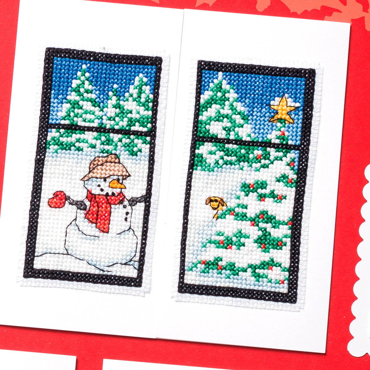 Cross-stitched design of a snowman and Christmas tree on a red card