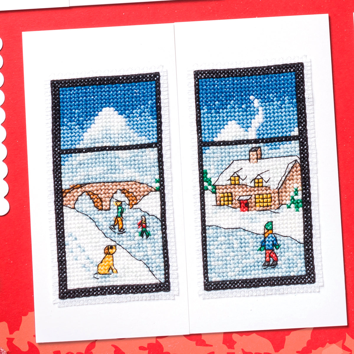 Cross-stitched scene of a snowy landscape with people and a dog, framed by windows on a red border.