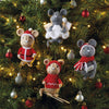Knitted mouse ornaments on a Christmas tree with lights and decorations.