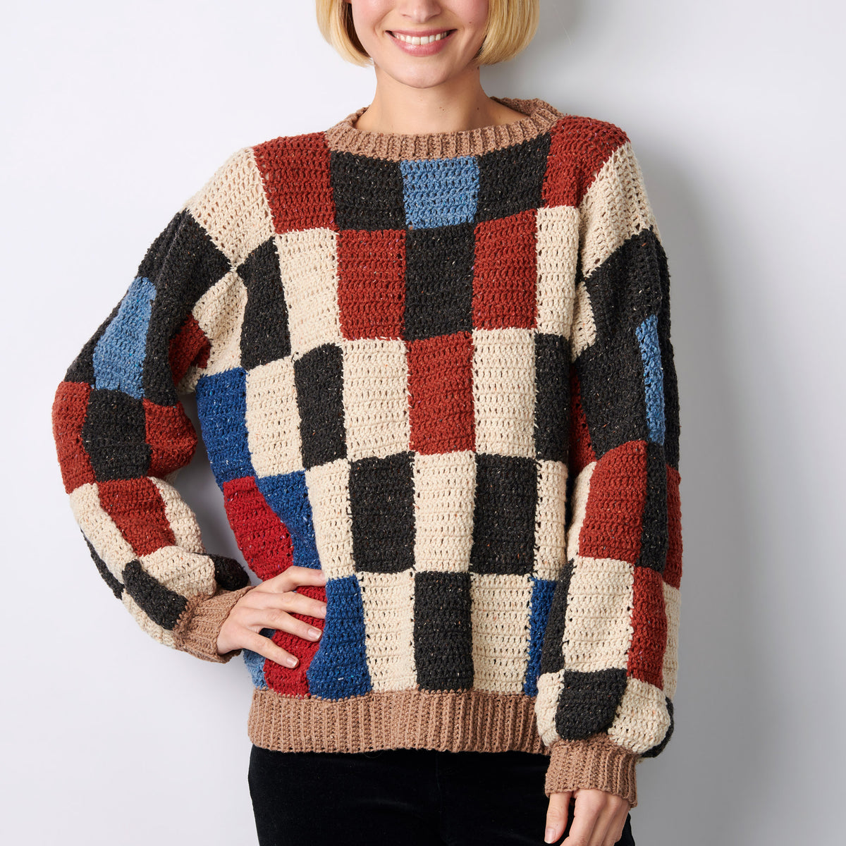 Person wearing a colorful checkered sweater against a plain background