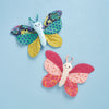 Two colorful butterfly toys on a light blue background