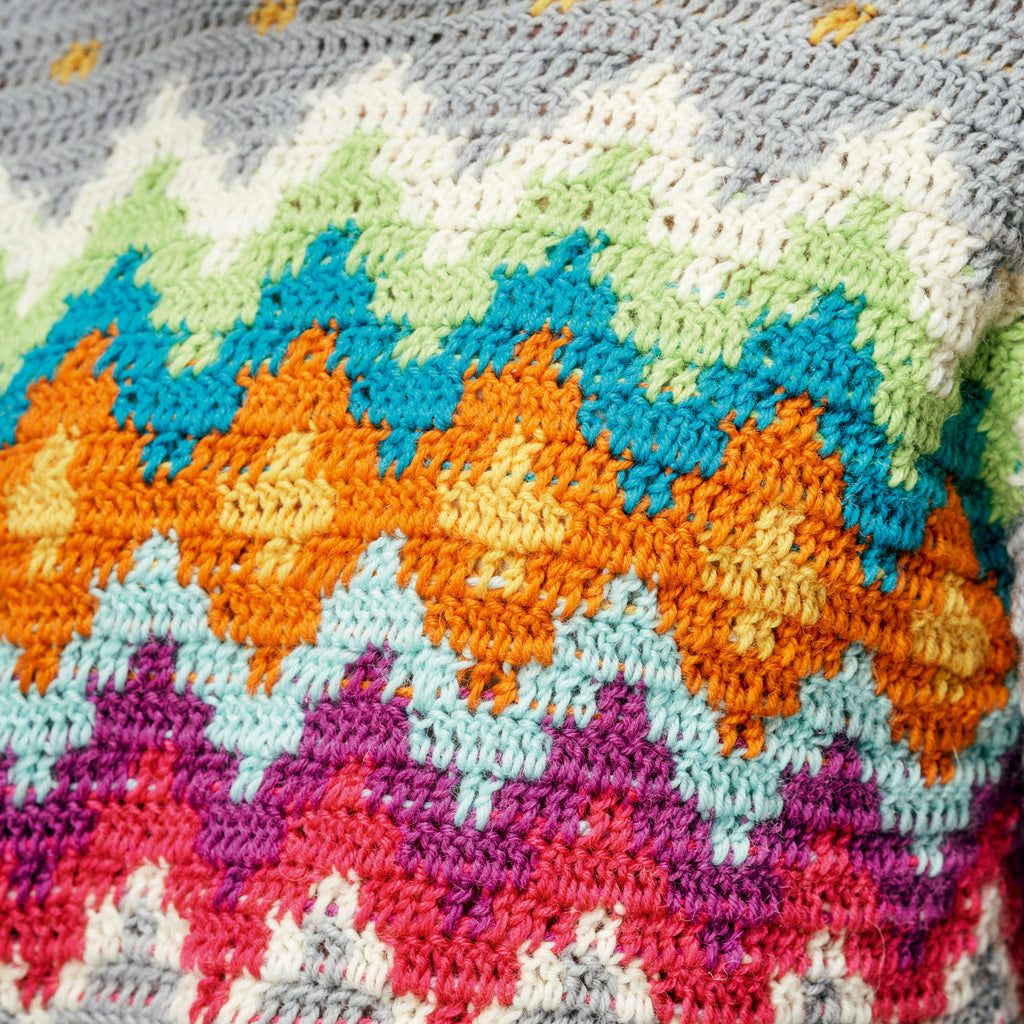 Close-up of a colorful crocheted blanket with geometric pattern