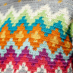 Close-up of a colorful crocheted blanket with geometric pattern