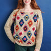 Person wearing a colorful crochet sweater against a blue background