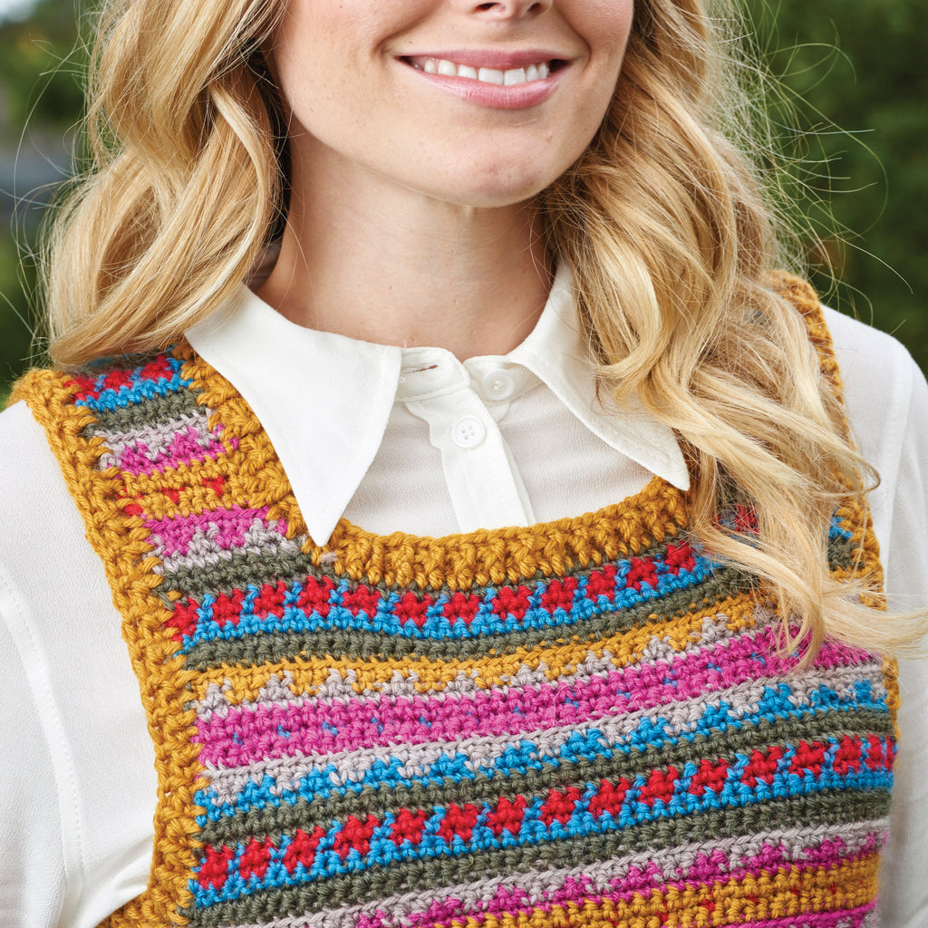 Woman wearing a colorful striped apron over a white shirt with a blurred green background