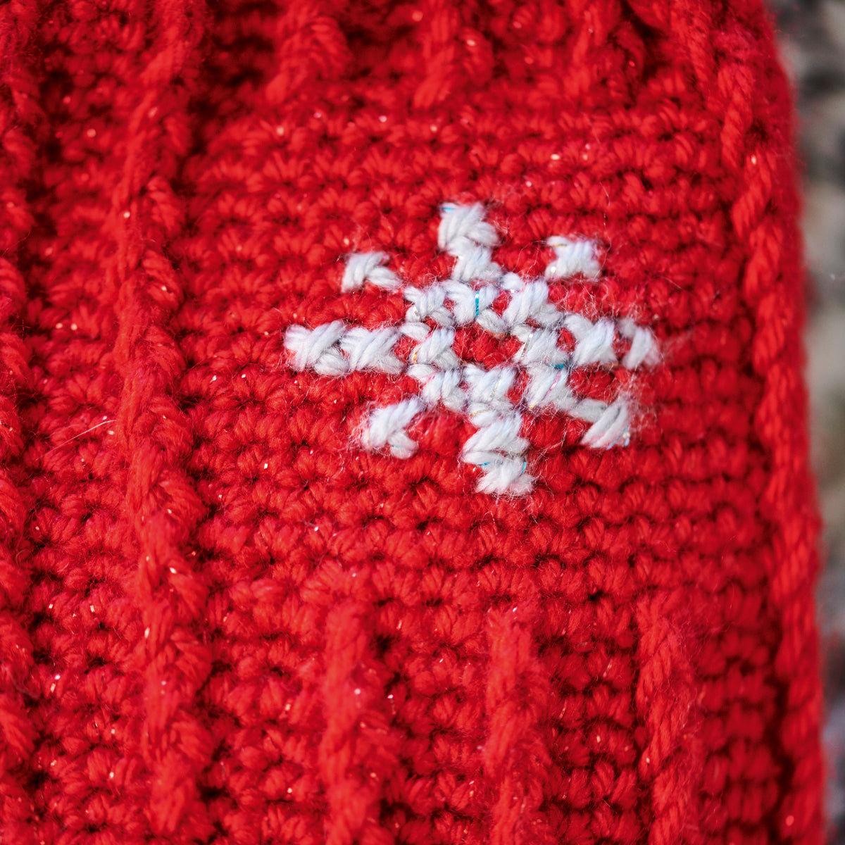 Red crochet fabric with a white snowflake design