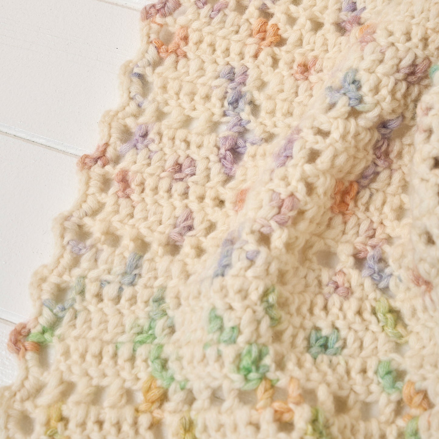 Knitted blanket with colorful flower patterns on a white background
