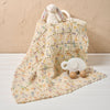 Crocheted baby blanket with toys on a beige background