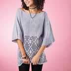 Woman wearing a light blue crochet poncho against a pink background