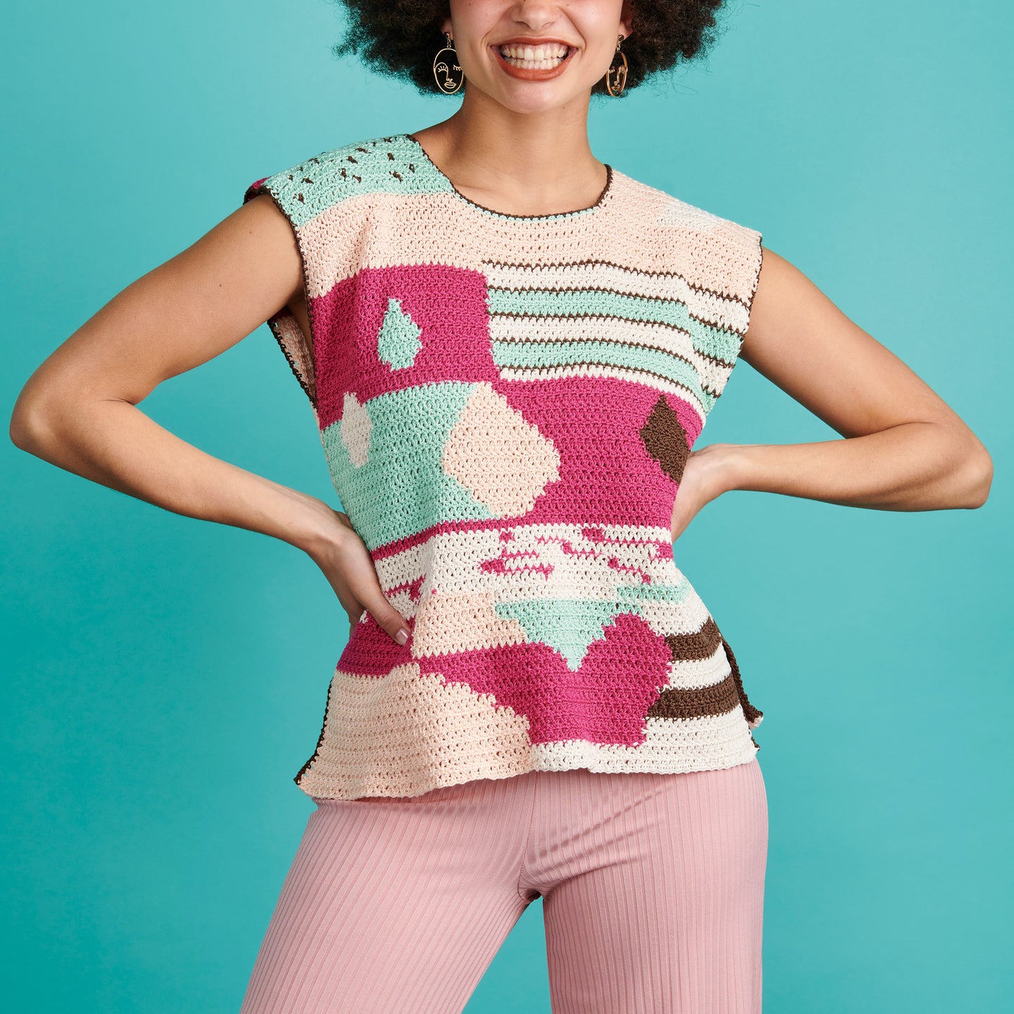 Woman wearing a colorful patterned sleeveless top against a teal background