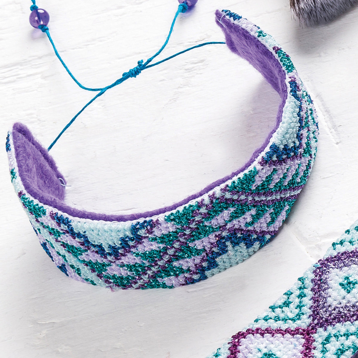 Colorful knitted headband with a geometric pattern on a white background