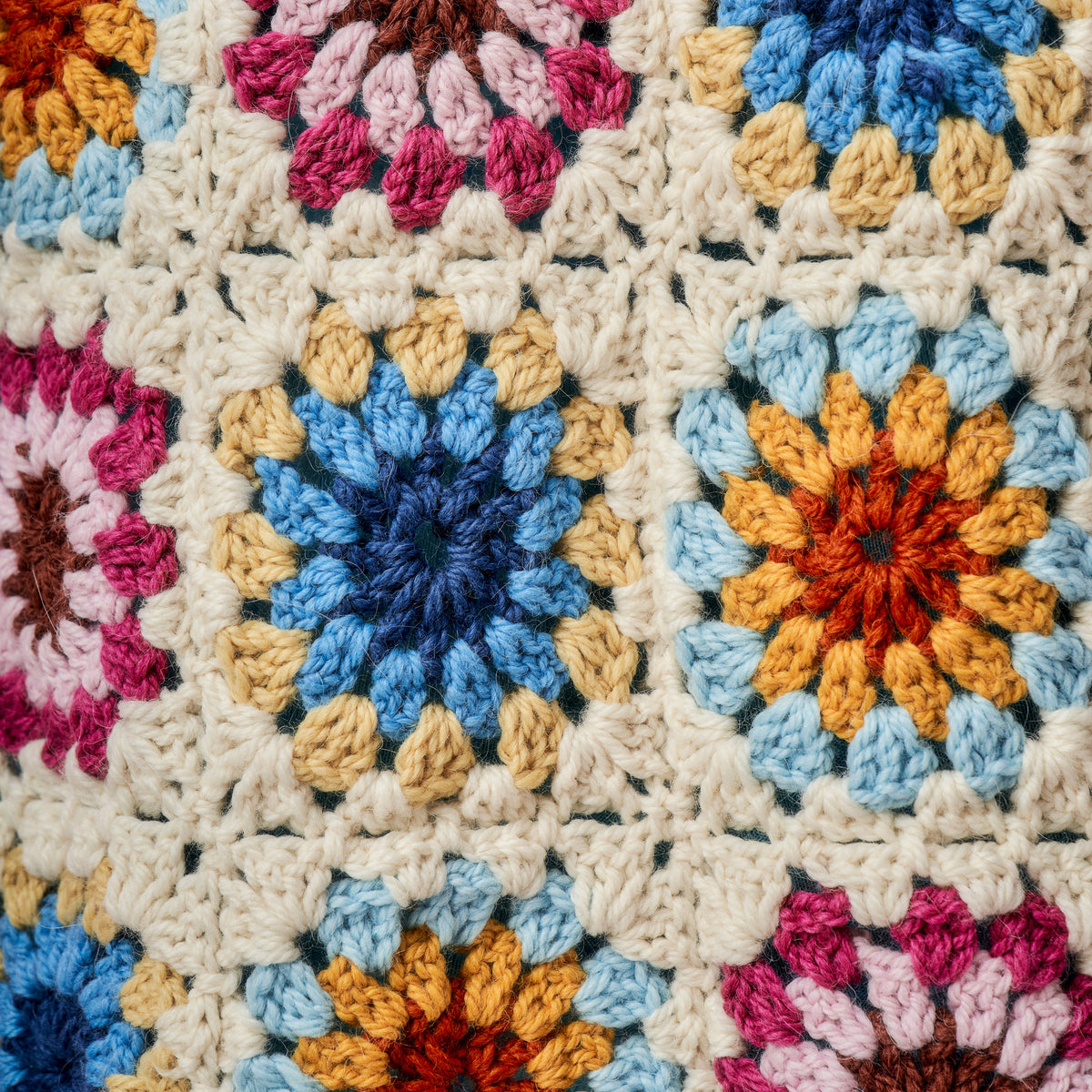 Close-up of a colorful crocheted blanket with various patterns.