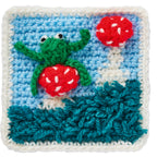 Crocheted square with a green frog and red mushrooms on a blue background