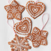Decorative gingerbread ornaments with white icing patterns on a light background